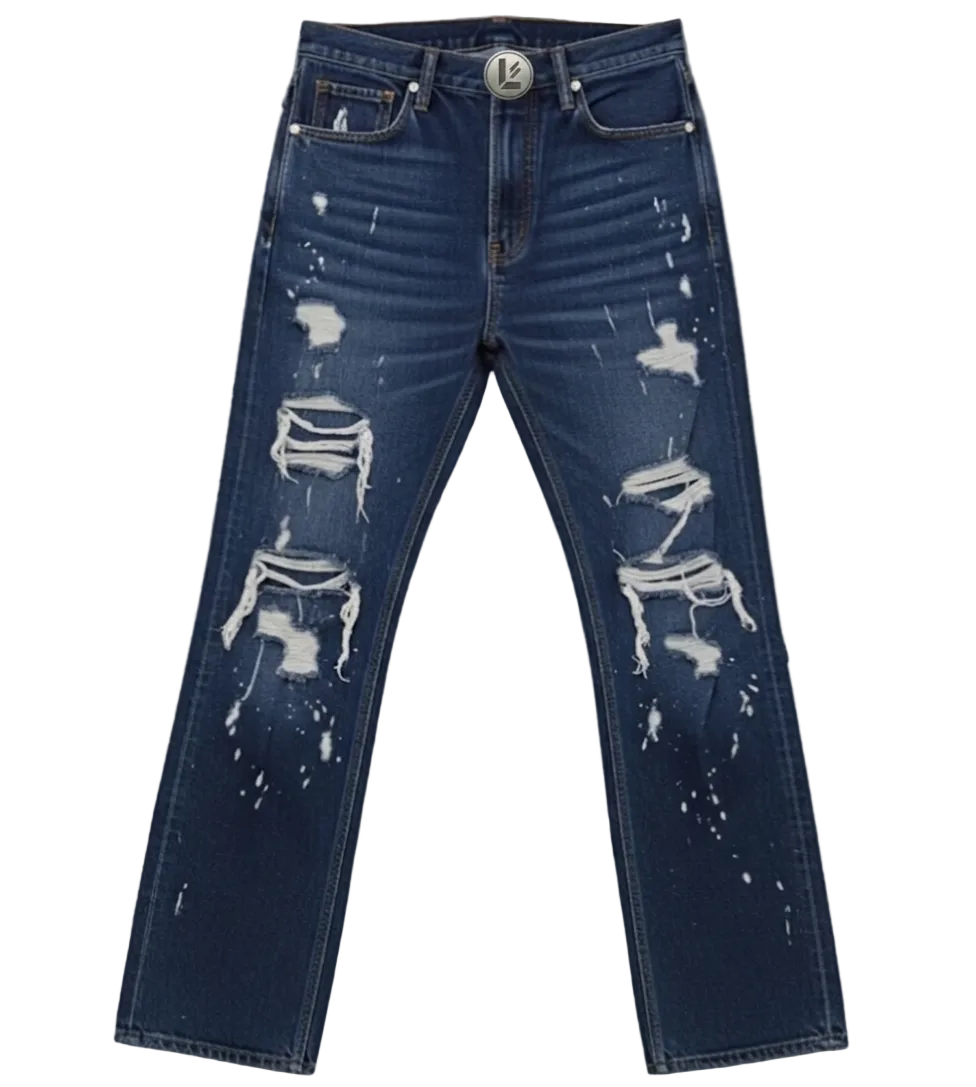 Distressed blue denim jeans with white paint splatter and ripped details, laid flat on a cracked gray concrete surface.