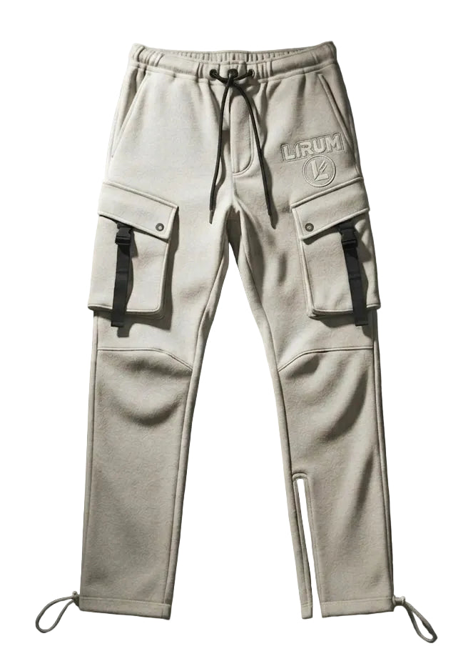 A pair of light beige cargo sweatpants with black drawstrings, side cargo pockets, and a circular 'LIRUM' logo patch on the left thigh, displayed flat against a dark wood plank background.